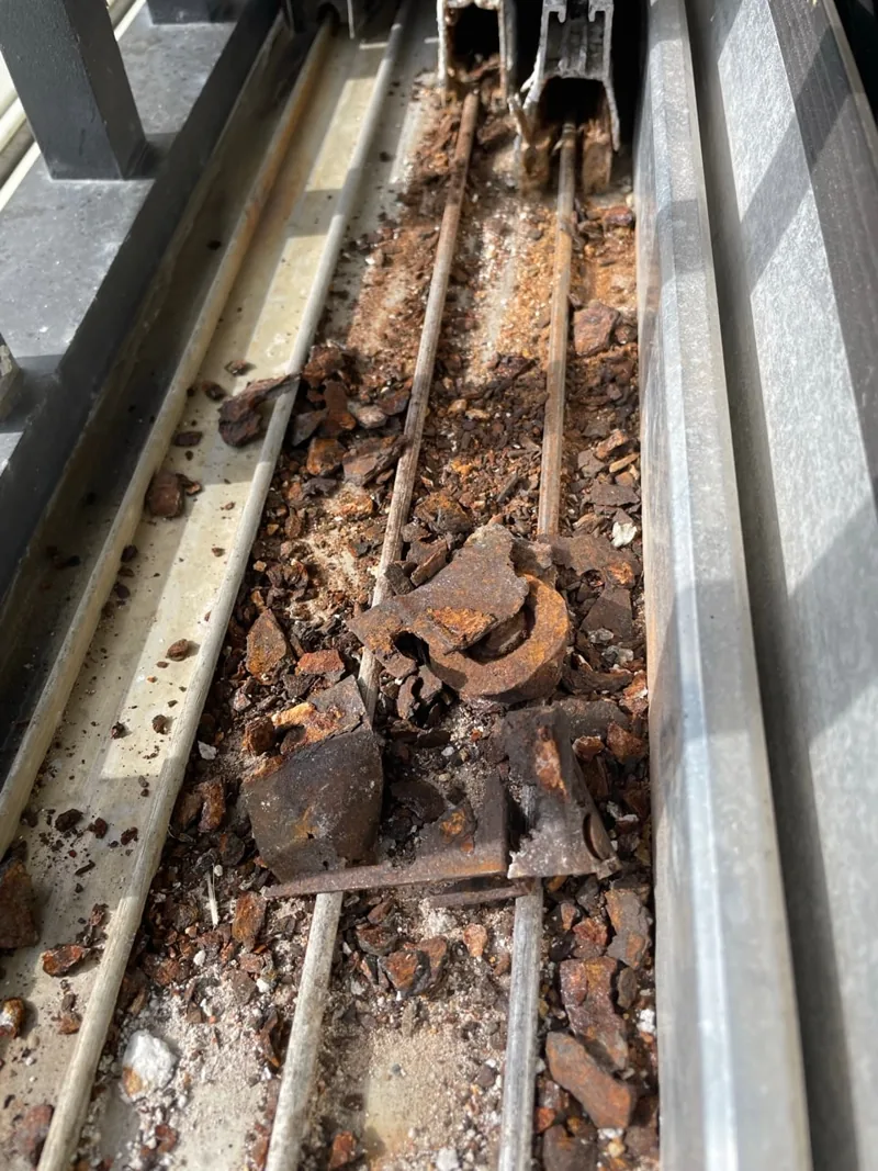 Corroded, debris-filled sliding door track before SliderPro service