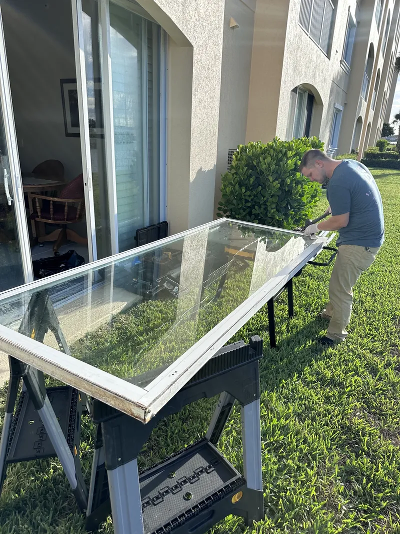 Sliding glass door panel lifted out of its frame and resting on sawhorses during a repair