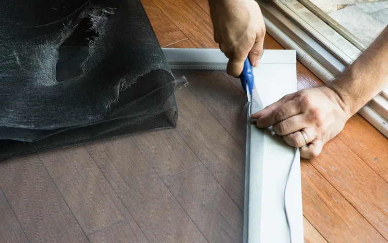 Technician re-screening a patio door frame with new fabric
