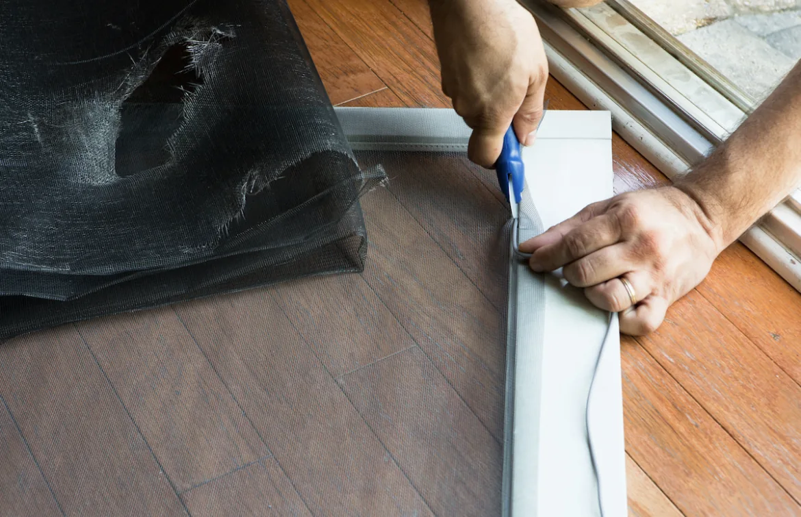SliderPro technician fitting new screen fabric into a patio door frame