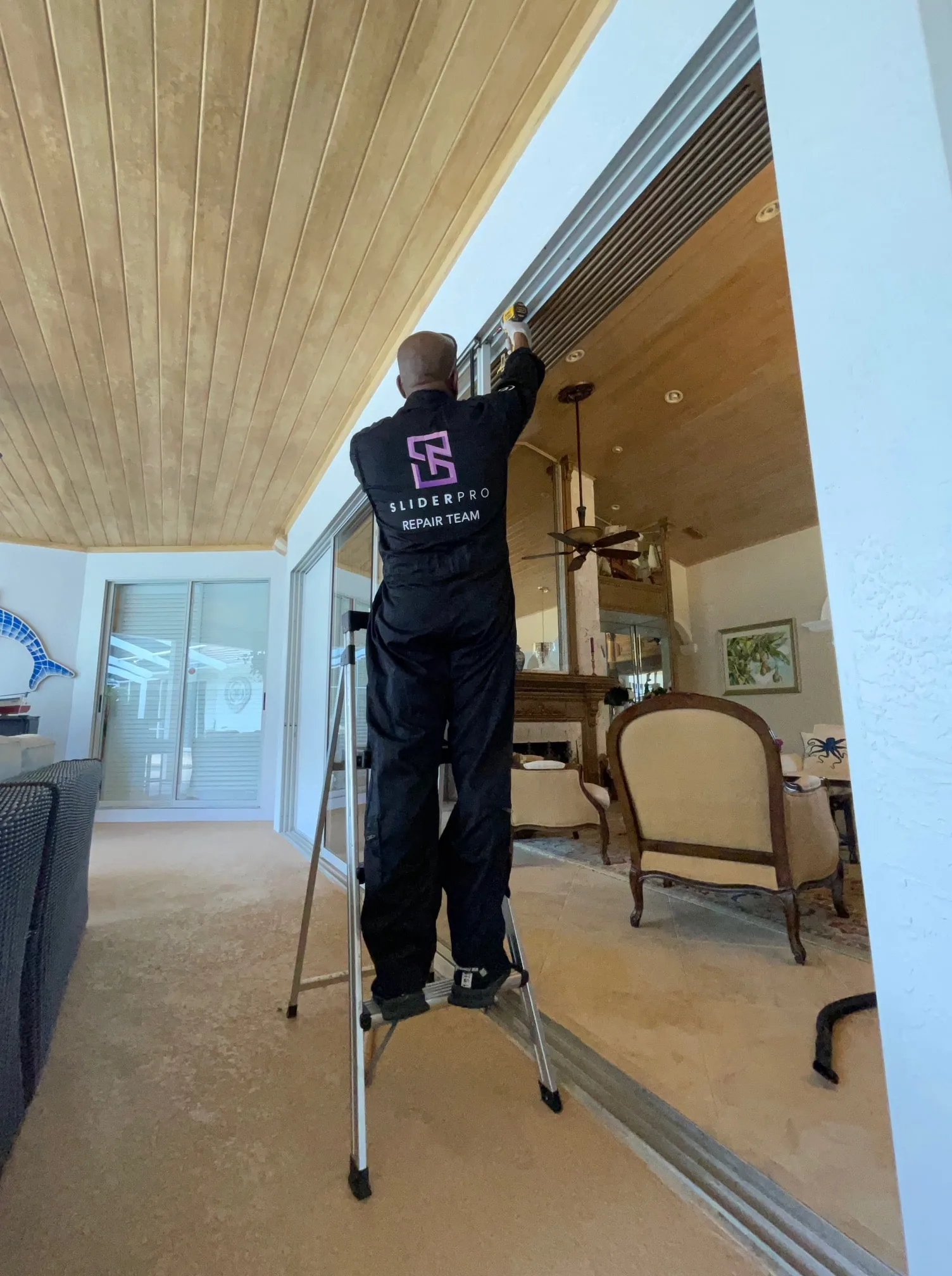 SliderPro technician servicing a sliding glass door inside a Treasure Coast home