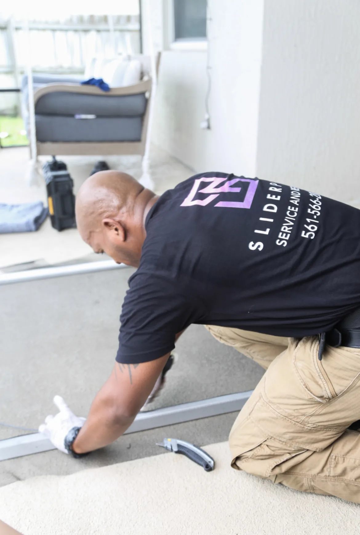 Technician working on the bottom track of a sliding glass door