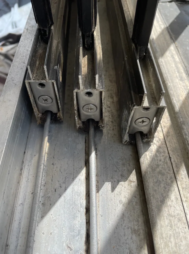 Worn sliding door rollers on their rails, mid-service